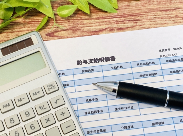 電卓と書類を使って家計や収支を計算している様子