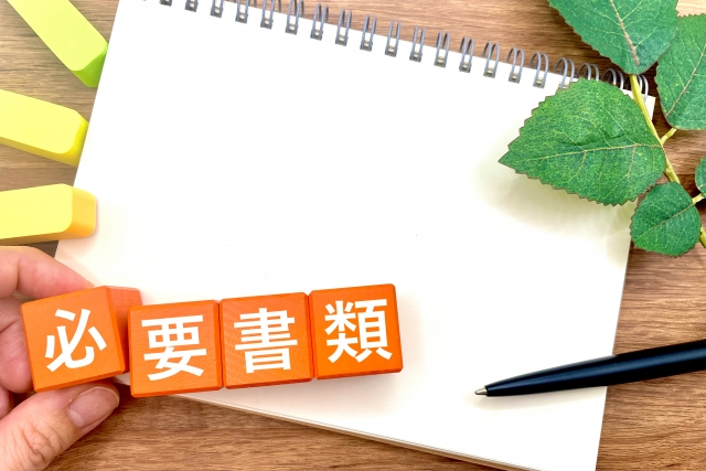 「要書類」と書かれた紙とボールペンの写真