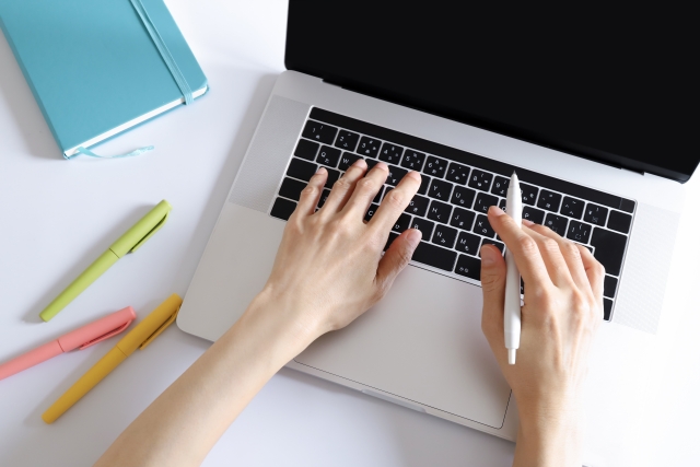 ノートパソコンでタイピングする手元の写真。ブログ執筆やライティング作業をイメージしたデスク風景。