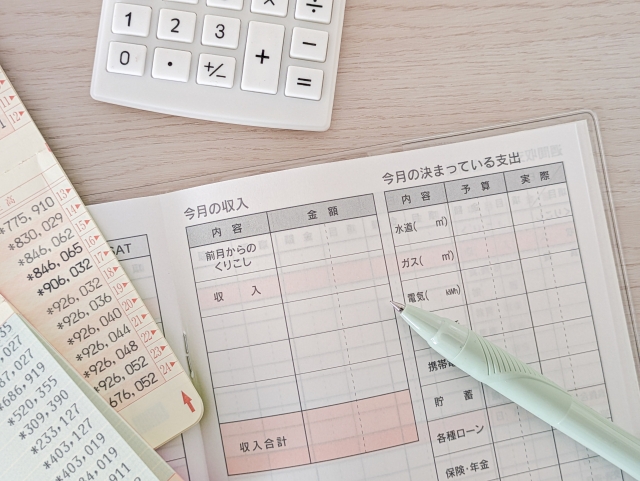電卓や家計簿を使って家計を記録・管理する様子を表す写真