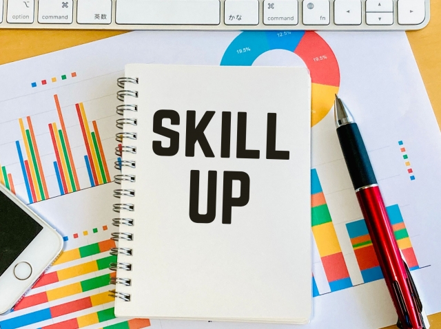 SKILL UPと書かれたノートと文具の写真｜資格勉強やスキルアップのイメージ