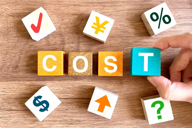 COSTの文字ブロックと電球アイコンが並んだ費用やコストをイメージしたデザイン