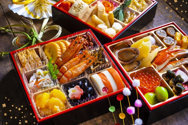 お重箱に黒豆や数の子、伊達巻、海老などが彩りよく盛り付けられたおせち料理の写真。