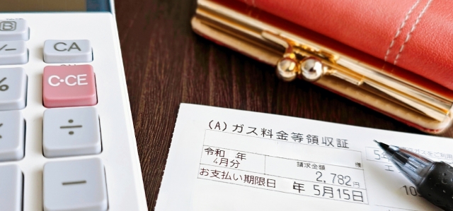 ガス料金の検針票とボールペンの写真。実際のガス代を見直す際に確認すべき請求書の項目を示している。