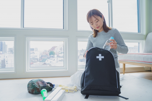 防災に備えてリュックを確認している女性の写真