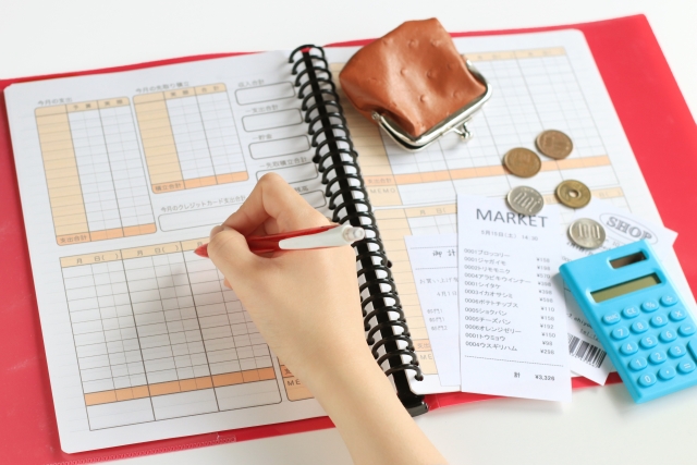 家計簿を電卓でつけているイメージ